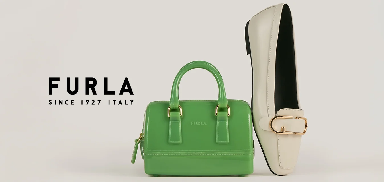 Piccola borsa in pelle verde accanto a un mocassino color crema con fibbia dorata su uno sfondo bianco neutro.