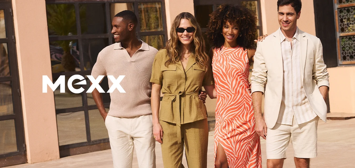 Quattro adulti stanno davanti a un edificio, indossando abbigliamento estivo casual: una camicia beige, una tuta verde, un vestito arancione e un blazer chiaro abbinato a pantaloni corti.