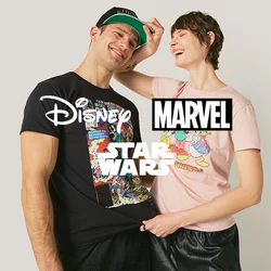 Due giovani adulti sorridenti, uno indossa una maglietta nera a tema fumetti e un cappellino, l'altro si sta sistemando il cappellino e indossa una maglietta rosa con un personaggio dei cartoni animati.