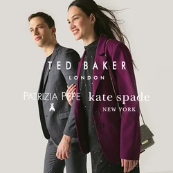 Uomo e donna che camminano fianco a fianco, donna con blazer viola e vestito nero che tiene una piccola borsa a catena, uomo in abito grigio scuro.