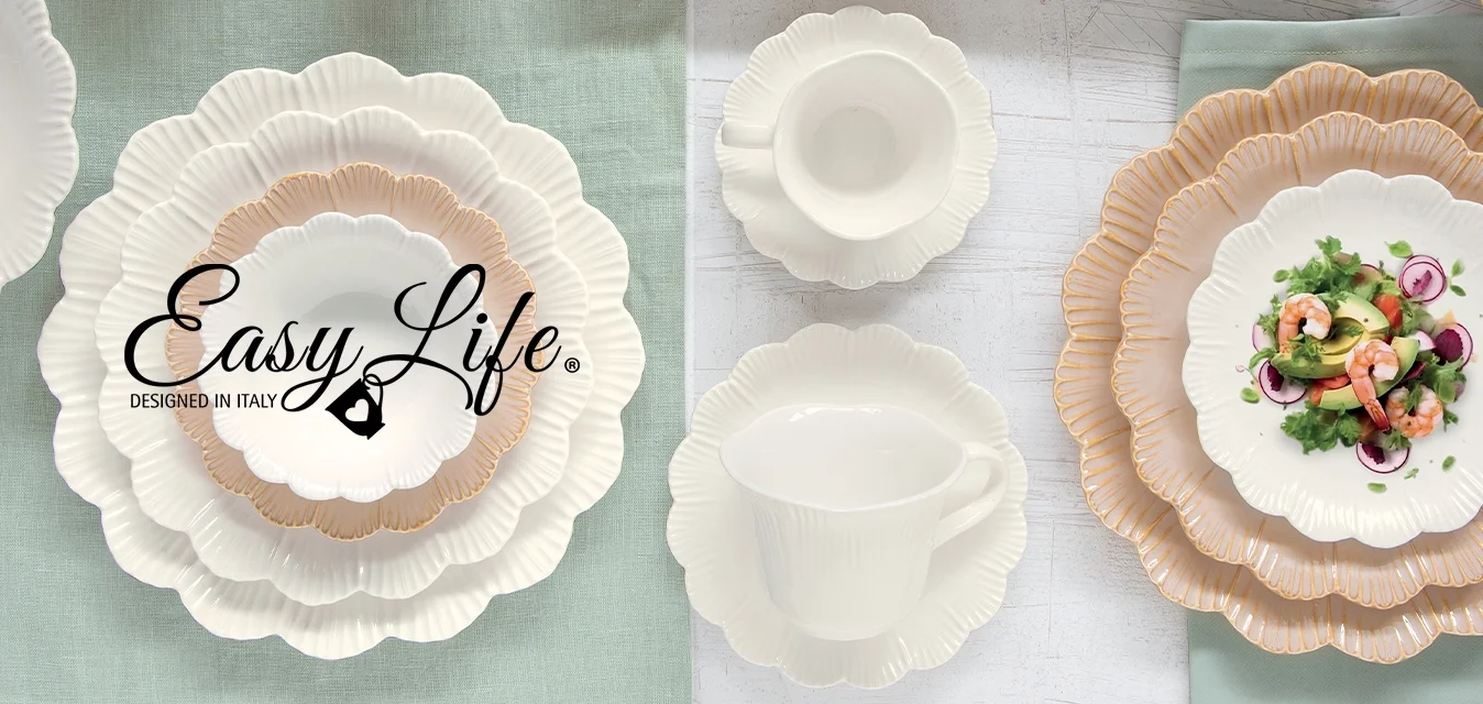 Piatti, ciotole e tazze in ceramica bianca e beige con bordi a scallop, disposti su sfondi verdi e bianchi, con un'insalata su un piatto e un rametto di verde.