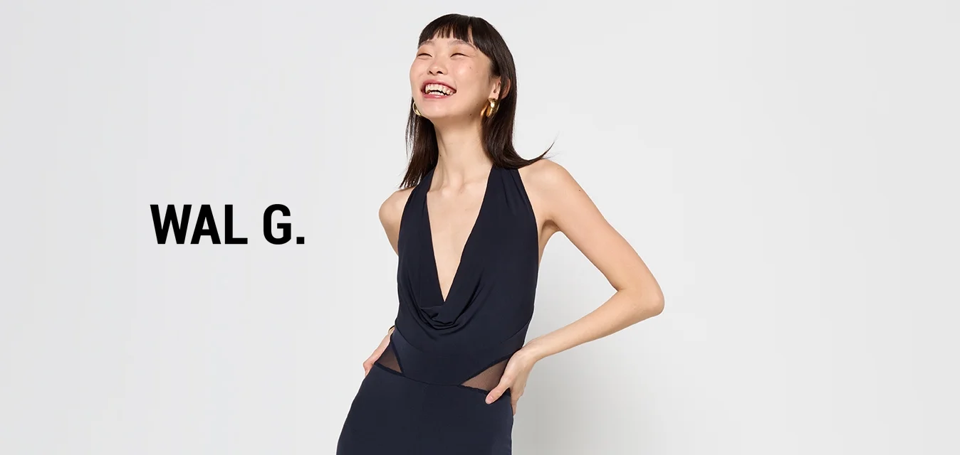 Jumpsuit blu navy con scollatura a V profonda e davanti drappeggiato. Presenta gambe aderenti e una texture di tessuto morbido e aderente. Design minimalista.