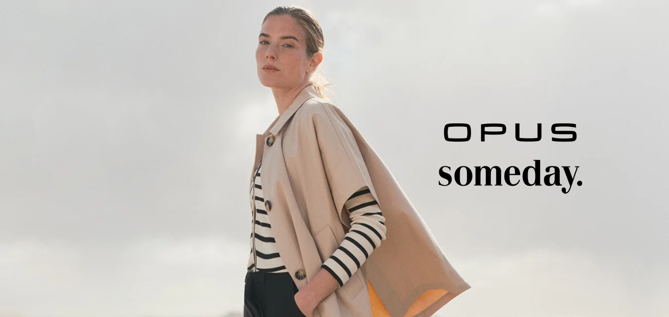 Giacca cropped beige con un bottone, indossata sopra una camicia a righe bianco e nere. I pantaloni neri a gamba larga e le ballerine nere a punta completano l'outfit.