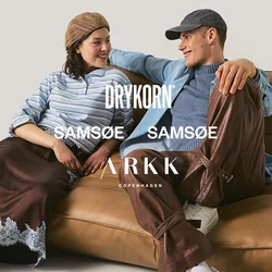 Due giovani adulti con abiti casual seduti e appoggiati su un divano marrone imbottito, sorridenti e che si guardano reciprocamente.