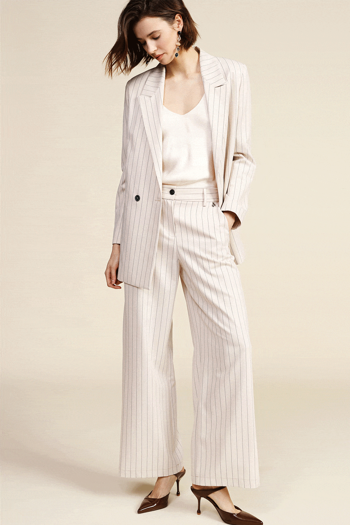 Collage of four women modelling tailored women's suits: cream pinstripe, herringbone, bold red and pale blue for work or events
