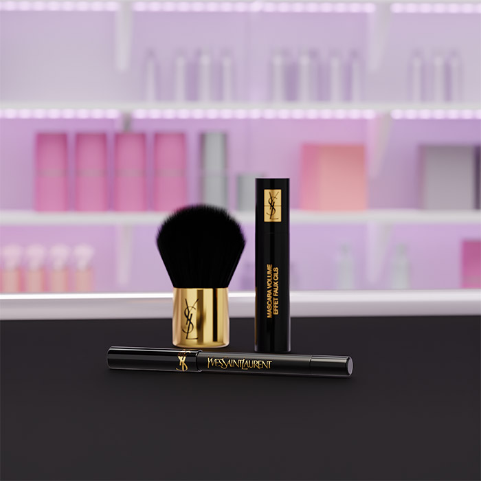 Un eyeliner, un mascara e un pennello YSL esposti su uno sfondo viola.