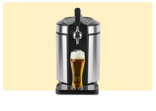 Stainless-steel countertop beer dispenser with tap pouring a frothy pint of lager into a glass