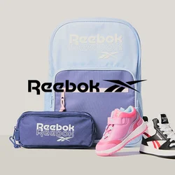 Zaino Reebok azzurro chiaro e viola, astuccio viola e due scarpe da bambino—una rosa, una bianca e nera—su sfondo grigio.