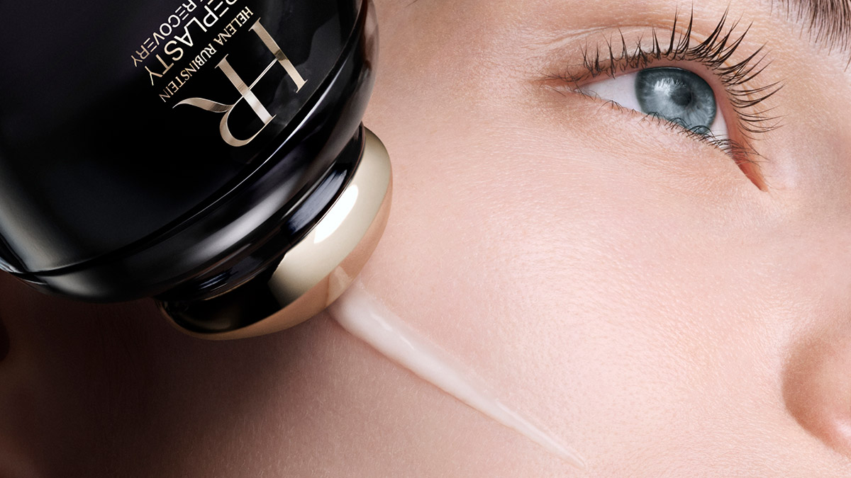 Applicazione precisa del trattamento Replasty Eye & Face Contour Concentrate sul viso di una donna con l'applicatore massaggiante nero e oro. 