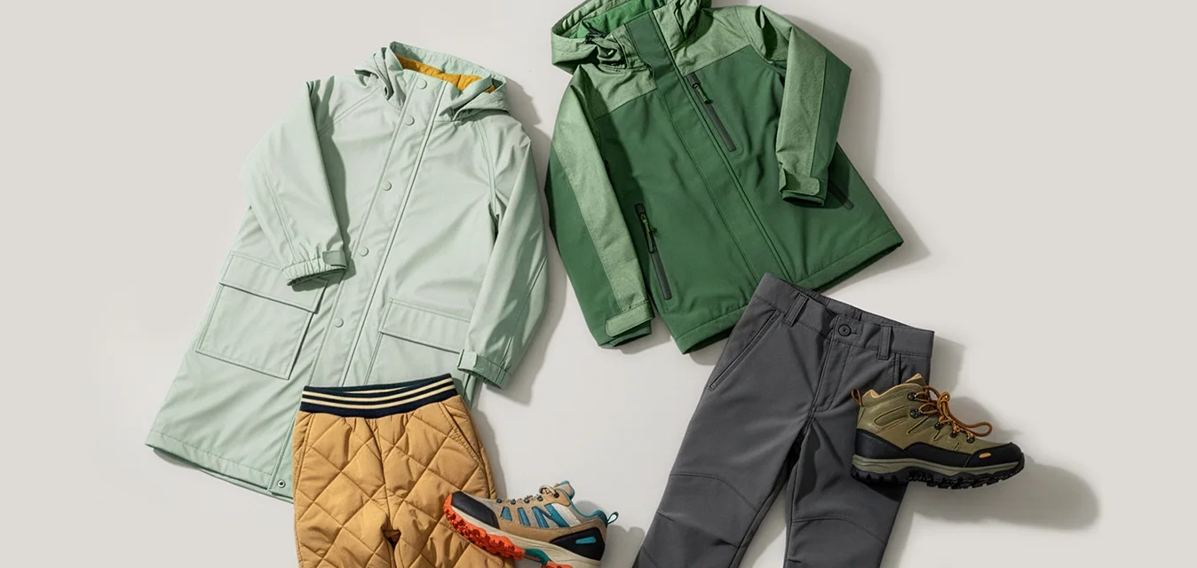 Due completi invernali per bambini: cappotto menta con pantaloni imbottiti senape e sneaker colorata, giacca verde con pantaloni grigi e scarponcino da trekking marrone.