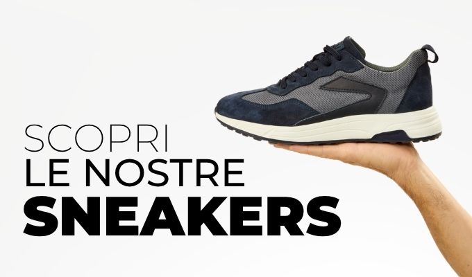 Hand holding a navy and gray sneaker on a white background with Italian promotional text 'Scopri le nostre sneakers'