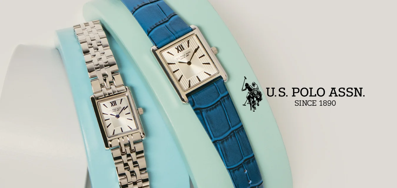 Due orologi da polso rettangolari con cinturini in pelle e metallo esposti su supporti curvi di colori pastello su uno sfondo chiaro.