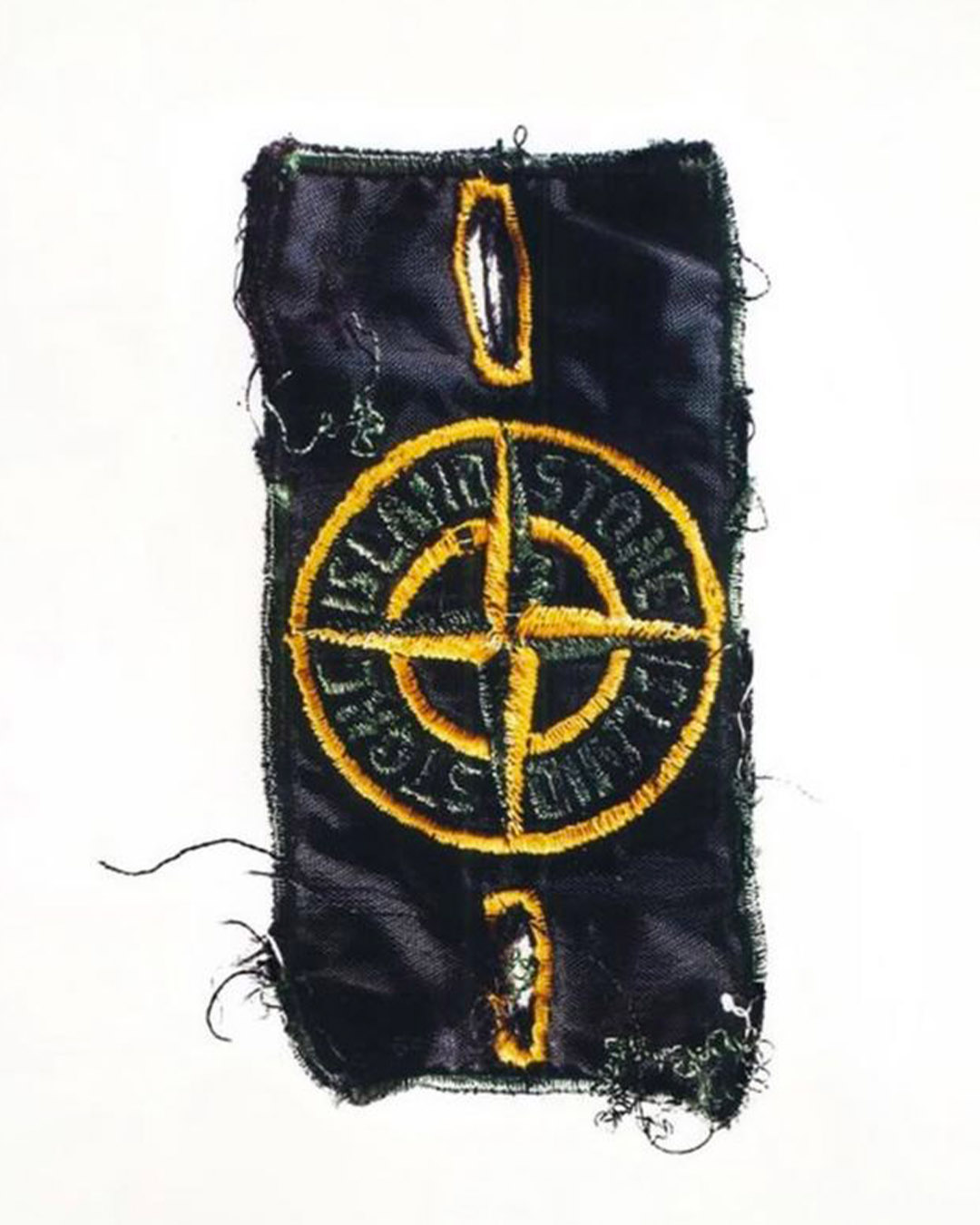 Worn black rectangular fabric patch with frayed edges, yellow embroidered circular compass logo and stitched buttonholes