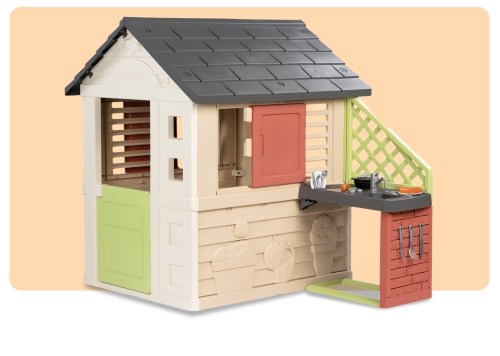 Children's outdoor plastic playhouse with grey roof, beige walls, green and red doors and attached play kitchen with sink