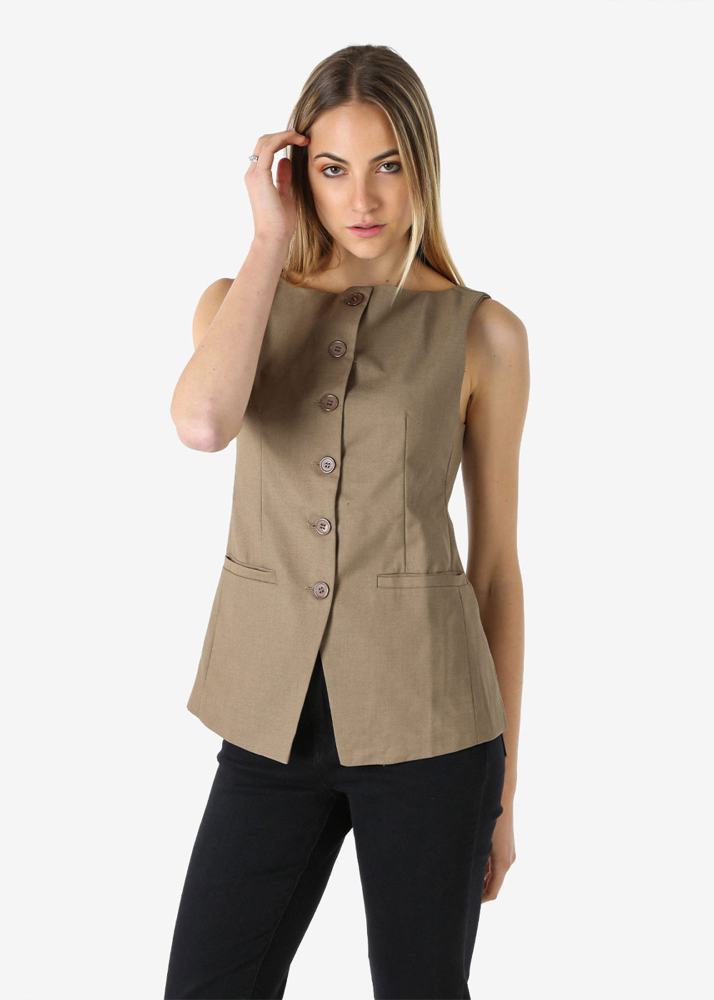 Woman modelling sleeveless taupe buttoned tailored vest with front welt pockets, paired with black trousers in studio pose