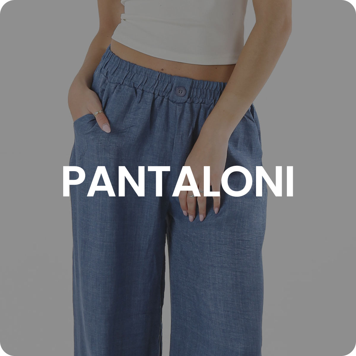 Blue wide-leg linen trousers with elasticated waist and side pockets worn with white cropped top, hands resting on hips