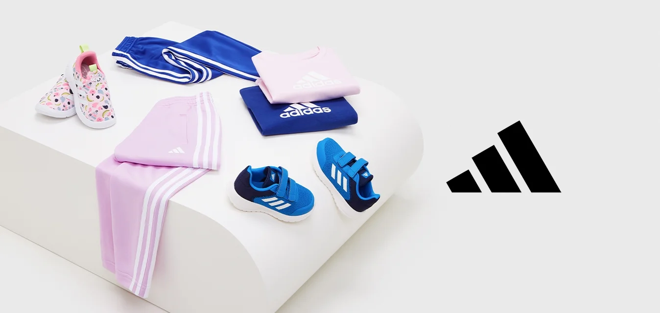 Abbigliamento sportivo e scarpe da ginnastica Adidas per bambini in design blu, rosa e floreale esposti su un piedistallo bianco.