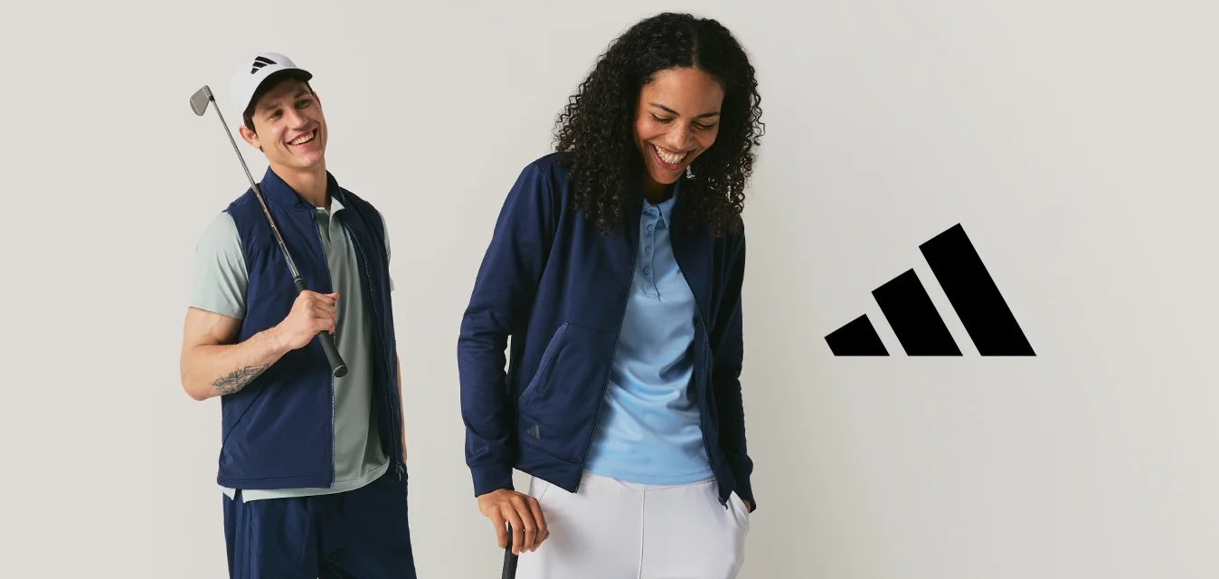 Due golfisti sorridenti che posano con bastoni da golf, vestiti con abbigliamento sportivo blu navy e azzurro, su uno sfondo chiaro e uniforme.