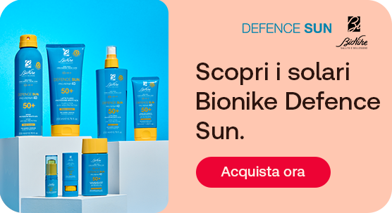 Prodotti solari BioNike Defence Sun (spray, creme e lozioni SPF 50+) su piedistalli azzurri. Testo: &ldquo;Scopri i solari BioNike Defence Sun&rdquo;. Pulsante rosso: &ldquo;Acquista ora&rdquo;.