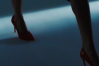 A person wearing high heels walks across a hard floor.