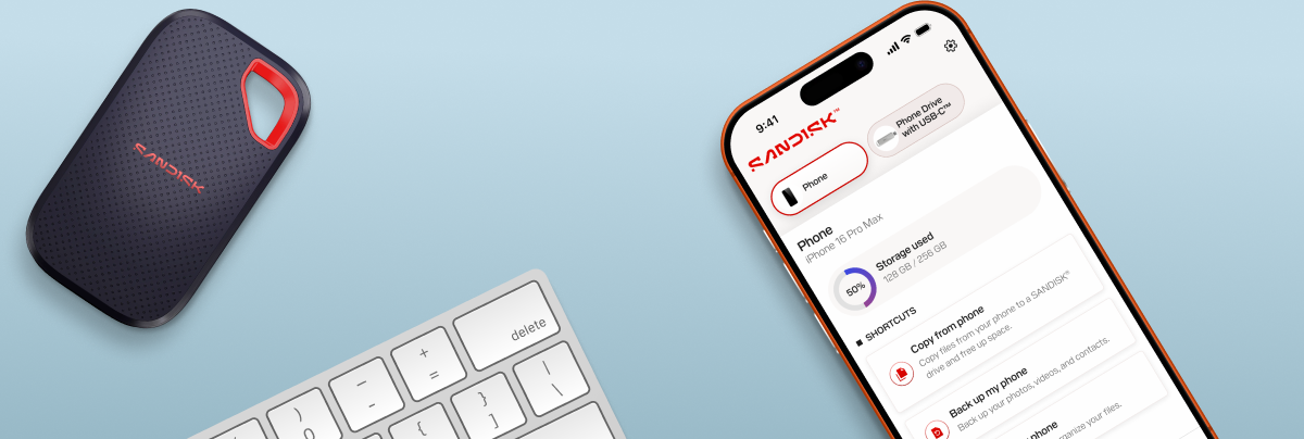 Immagine dall'alto di un'unit&agrave; portatile SanDisk, una tastiera bianca e un iPhone che mostra l'utilizzo dello spazio di archiviazione e le opzioni per copiare o eseguire il backup dei dati del telefono.