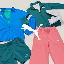 Due completi sportivi con marchio Puma: giacca blu, pantaloncini verdi, scarpe da ginnastica; giacca verde, pantaloni rosa, scarpe da ginnastica bianche, disposti su una superficie bianca.