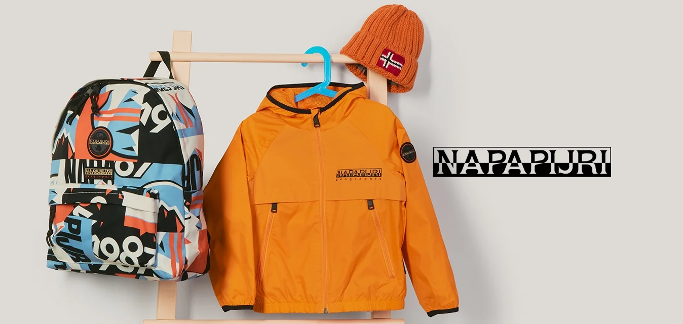 Zaino con motivo colorato, giacca arancione brillante su gruccia blu e cappello lavorato a maglia arancione con toppa della bandiera norvegese su appendiabiti di legno.