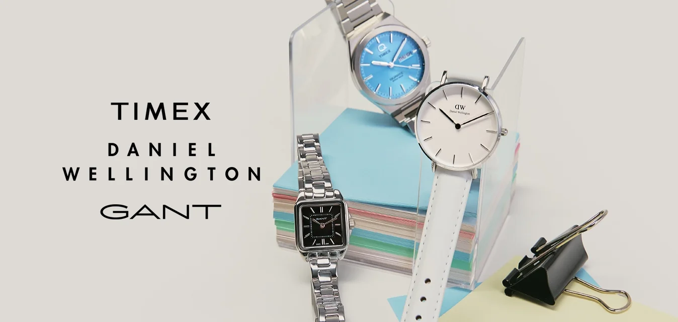 Tre orologi da polso mostrati su note adesive color pastello con una clip nera su uno sfondo chiaro.