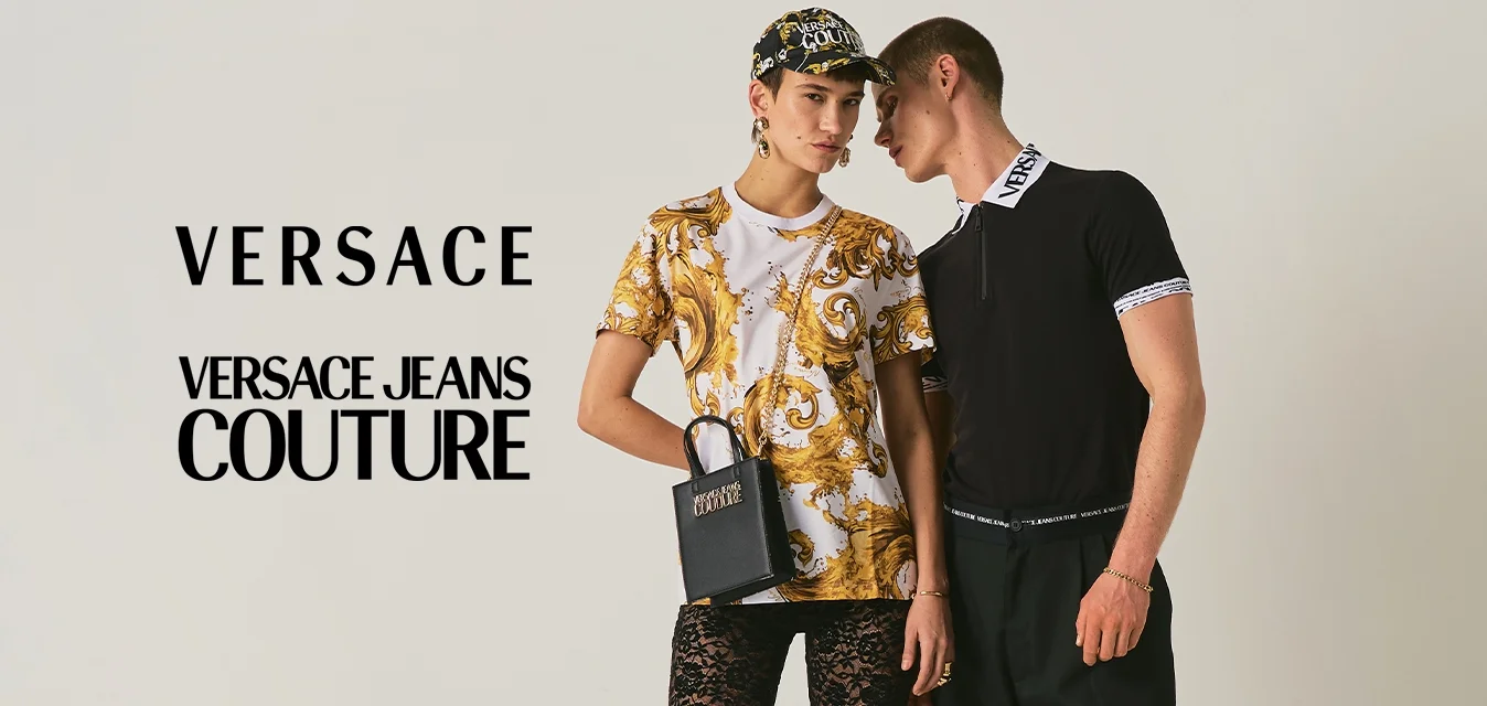 Due modelli posano: uno con camicia a motivo dorato, pantaloni neri in pizzo, cappellino da baseball, con una piccola borsa nera in mano; l'altro con top nero e pantaloni blu.