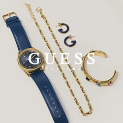 Orologio con cinturino in pelle blu, collana a catena d'oro, bracciale rigido d'oro con pietre colorate e due piccoli orecchini a cerchio blu e oro su sfondo grigio.