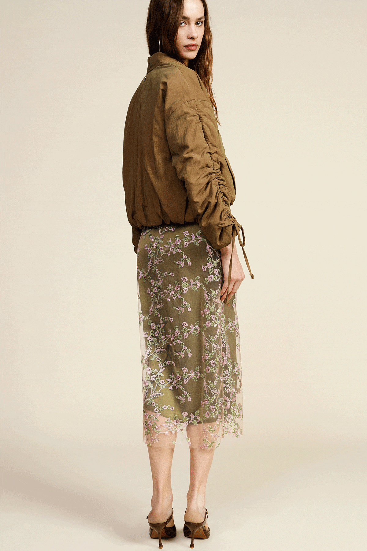 Two fashion looks: woman in navy and white striped tank with long red pleated skirt; close-up of white embroidered dress with waist tie and red buttons