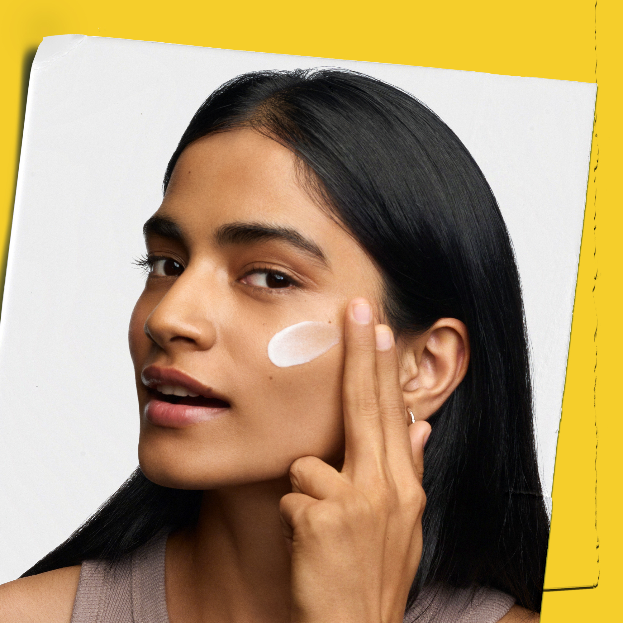 Modella che applica il Better Screen UV Serum di Kiehl's sulla guancia, con finish impalpabile e invisibile sulla pelle