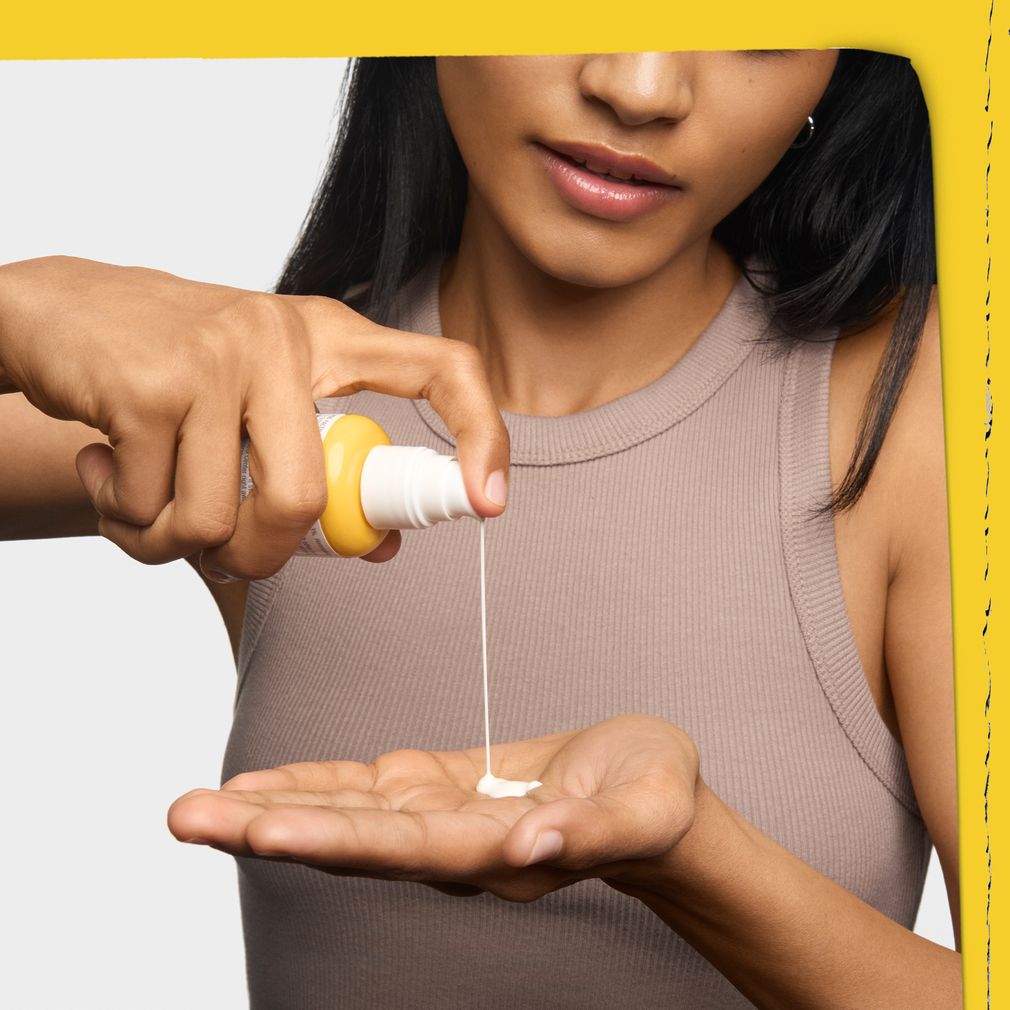 Modella che eroga il Better Screen UV Serum di Kiehl's dal flacone con pump, mostrando la texture fluida e leggera del prodotto