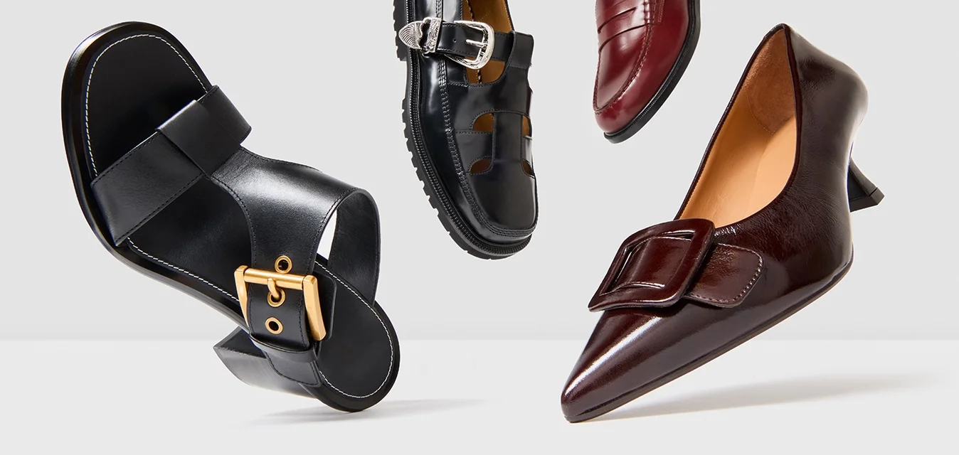 Quattro scarpe galleggianti su uno sfondo bianco: sandalino nero a ciabatta, sandalino nero con fibbia, mocassino rosso piccolo e décolleté marrone con tacco.