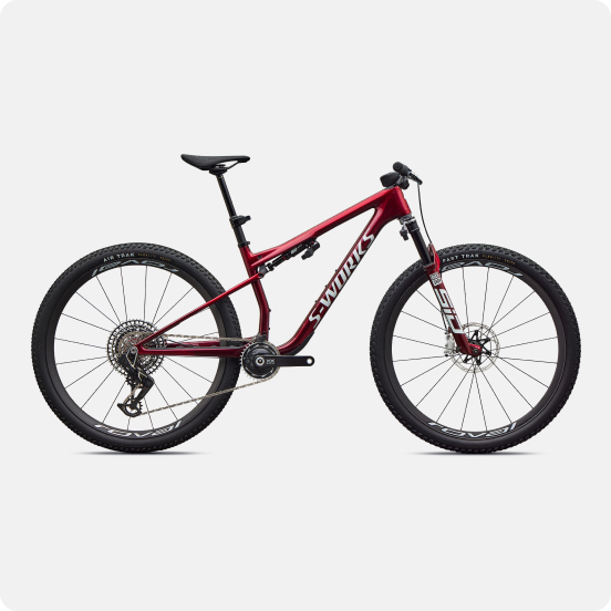 Side view of a red S-Works full-suspension mountain bike with disc brakes and knobbly tyres on a white background