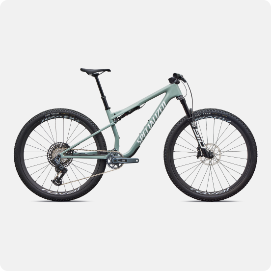 Side view of a mint-green full-suspension mountain bike with dropper seatpost and knobby tyres on a white background