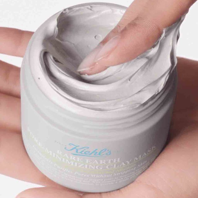 Mano che preleva la texture grigia della Rare Earth Deep Pore Cleansing Masque direttamente dal vasetto.