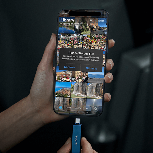 Lo schermo di un iPhone mostra un avviso &laquo;Storage Full&raquo;, mentre un'unit&agrave; USB-C SanDisk &egrave; pronta per la connessione al telefono.