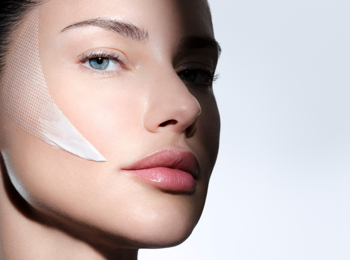 Ritratto del Top Model Adriana Lima che applica la texture skincare Bandage sulla guancia per ridensificare i volumi del viso.