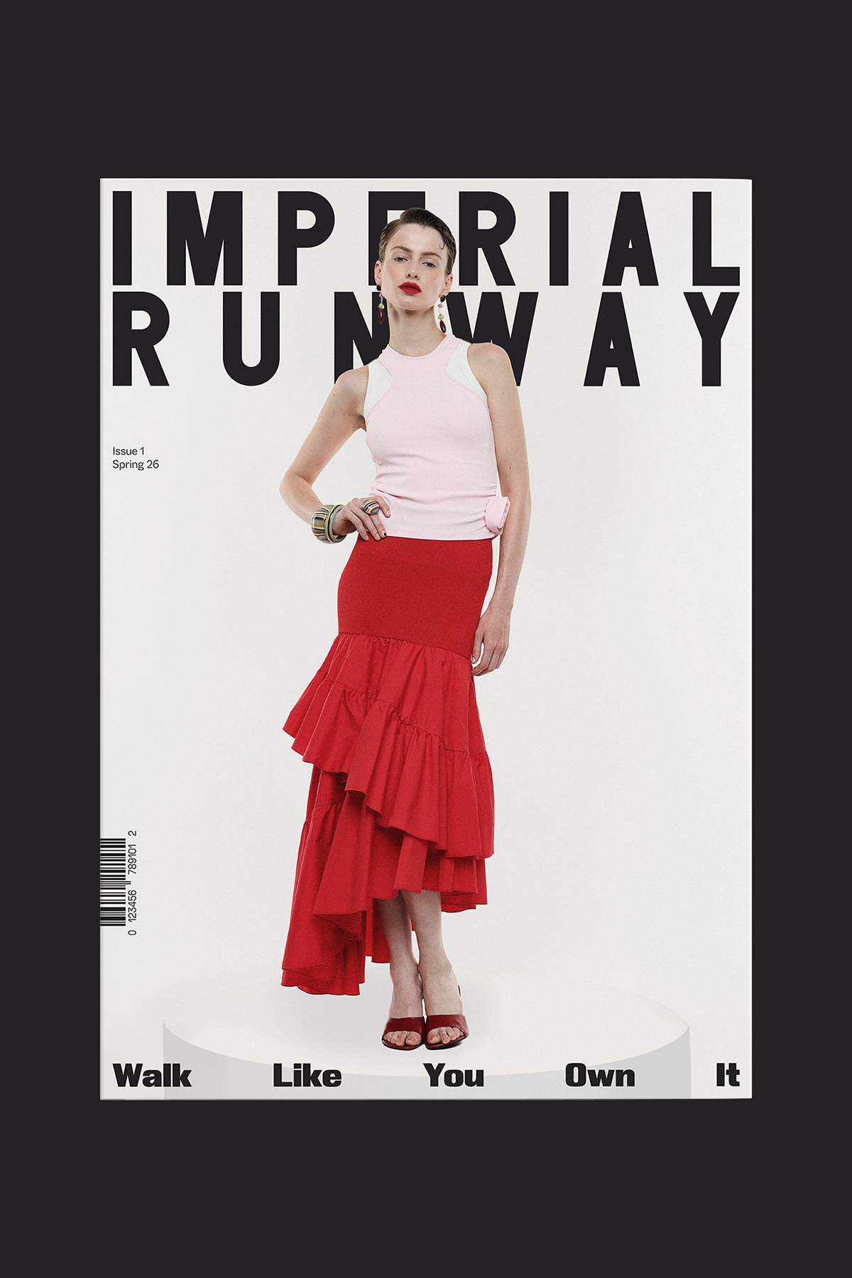Model on 'Imperial Runway' magazine cover wearing a pink sleeveless top and tiered red ruffled skirt standing on a white podium