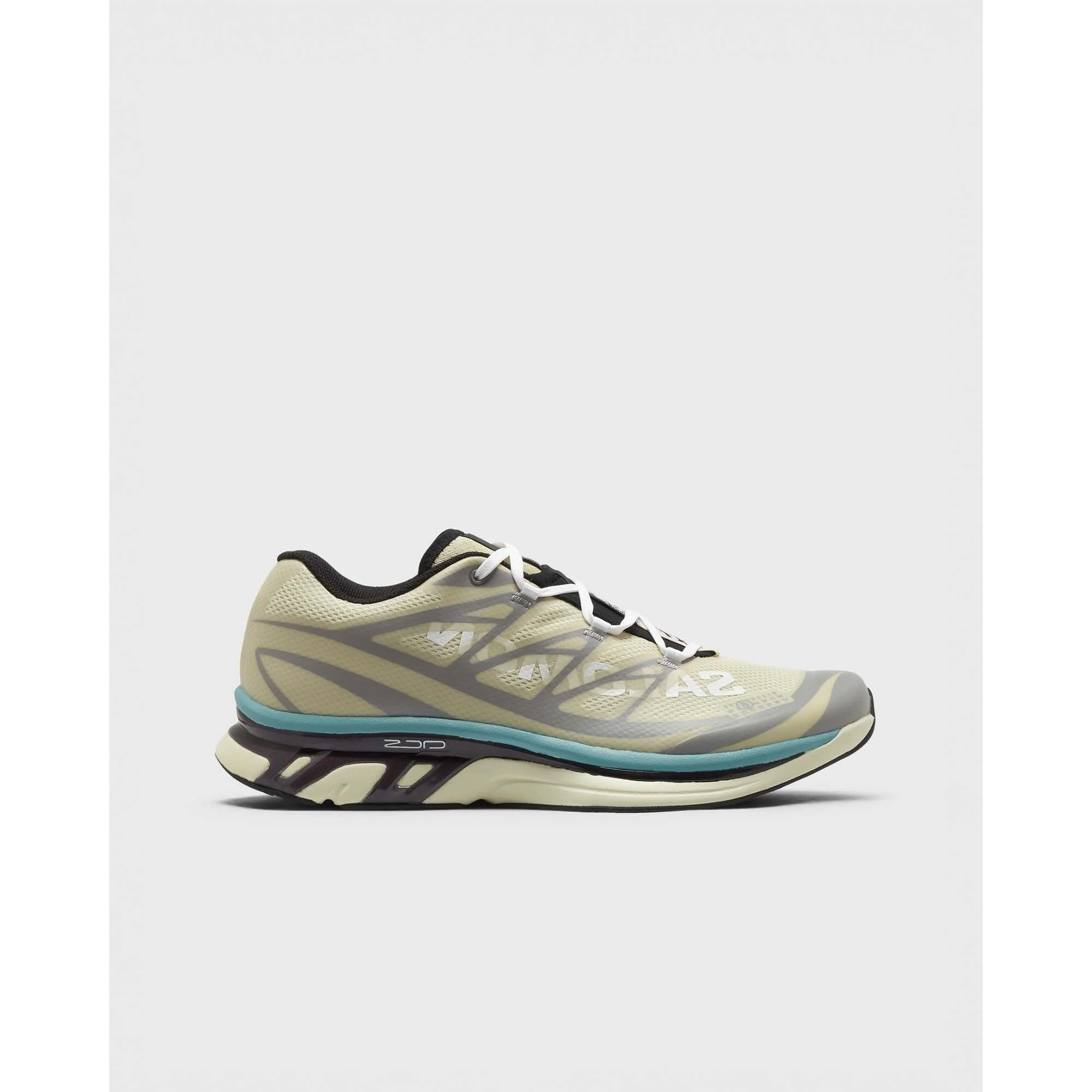 Side view of beige and teal running shoe with white laces and cushioned sole on plain white background — men's neutral trainer