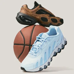 Scarpe da ginnastica marroni e azzurro chiaro appoggiate su un pallone da basket su uno sfondo grigio chiaro uniforme.