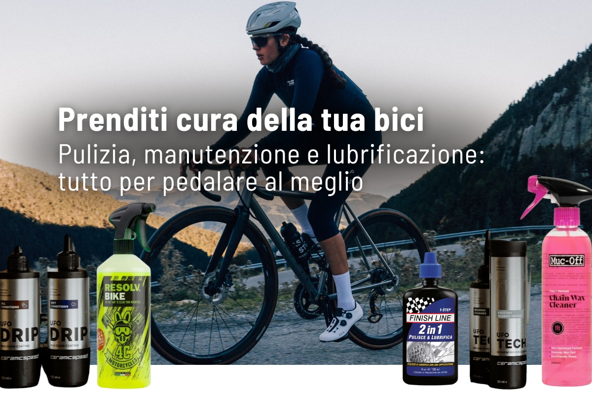 Cyclist riding a road bike on a mountain road with bike cleaning, maintenance and lubrication products displayed in the foreground