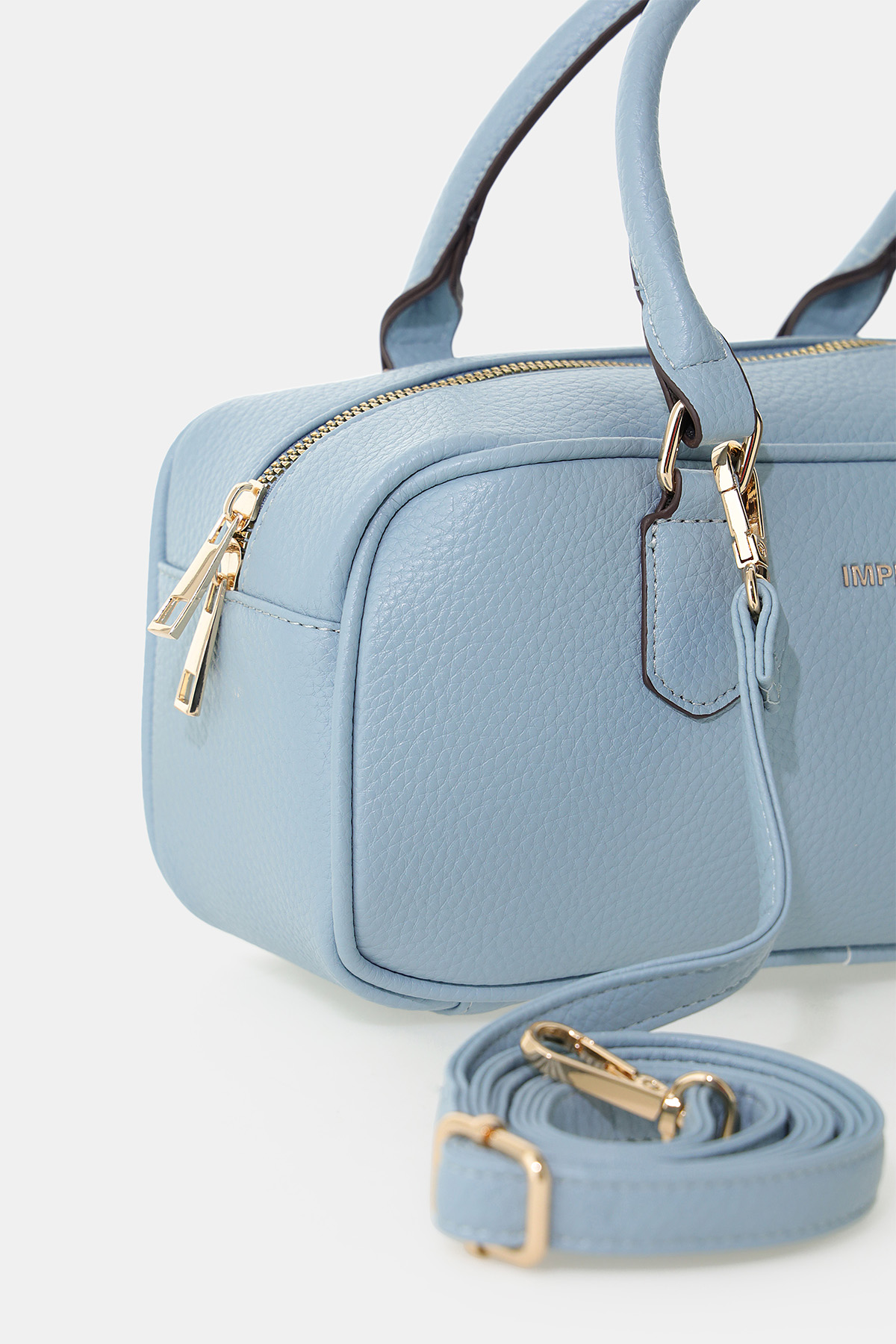 Light blue pebbled leather handbag with gold zips and detachable shoulder strap, structured rectangular crossbody bag