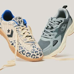 Due sneaker con i lacci slacciati che galleggiano una accanto all'altra; una in mesh blu-grigio e una beige con stampa animalier e suola in gomma.