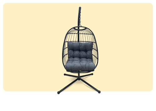 Modern black metal hanging egg chair with plush grey cushion on a freestanding stand, isolated on pale yellow background
