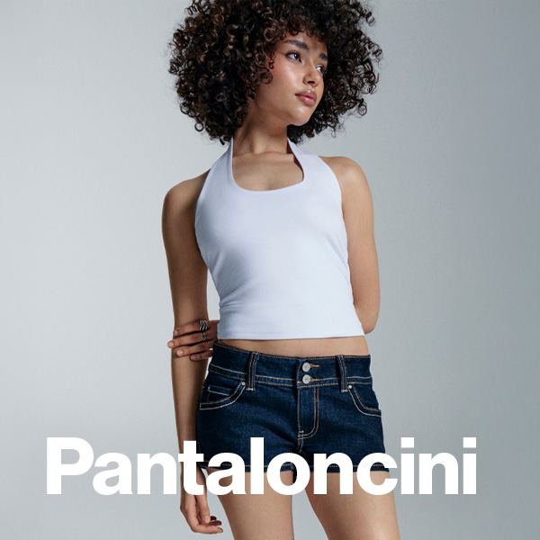 Pantaloncini. Modelka w białym topie i jeansowych szortach.