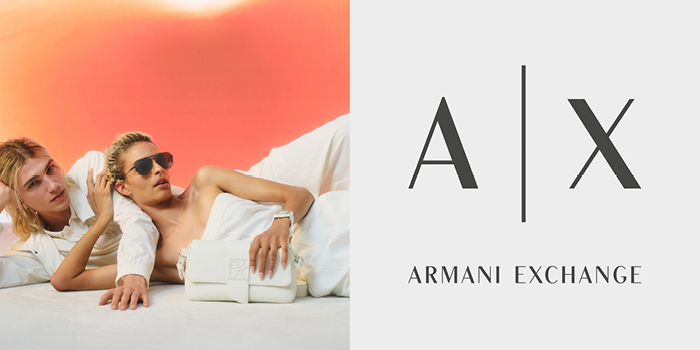 Two models reclining against orange backdrop with white leather Armani Exchange handbag and sunglasses, A|X logo on right