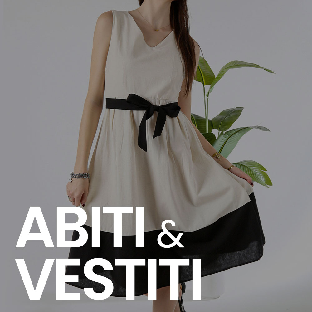 Woman in sleeveless beige dress with black bow belt and black hem, holding the skirt beside an indoor plant