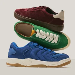 Tre sneakers in suede impilate: una blu, una verde con lacci bianchi e una bordeaux con dettagli beige sul tallone, su uno sfondo neutro.